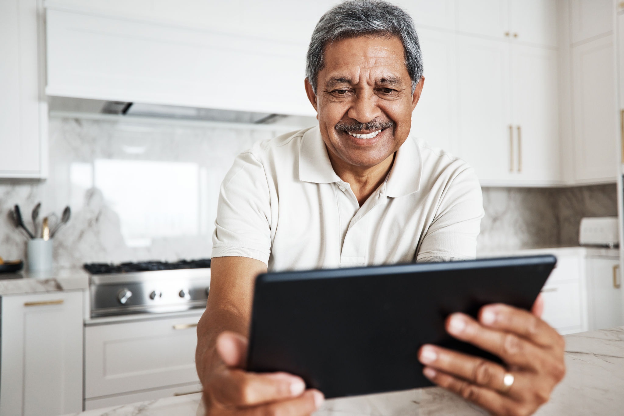 Mature man, tablet and home on social media, internet and reading online news application. Happy grandpa, digital technology and connection in house for networking, website search and ebook for smile.