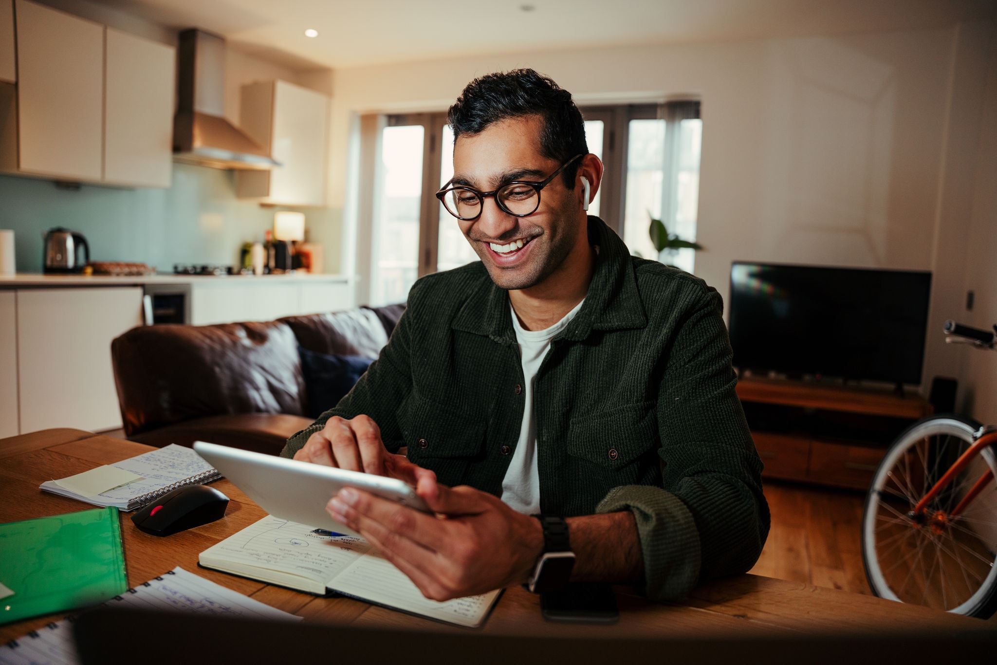 Smiling mixed race businessman face timing family from digital tablet feeling happy sitting at desk in home office . High quality photo
