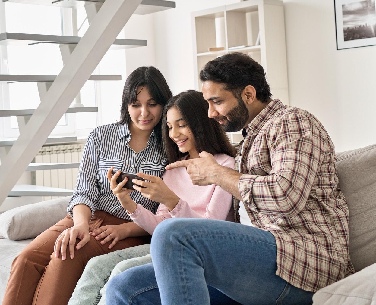 Happy family sitting on the couch and on the phone