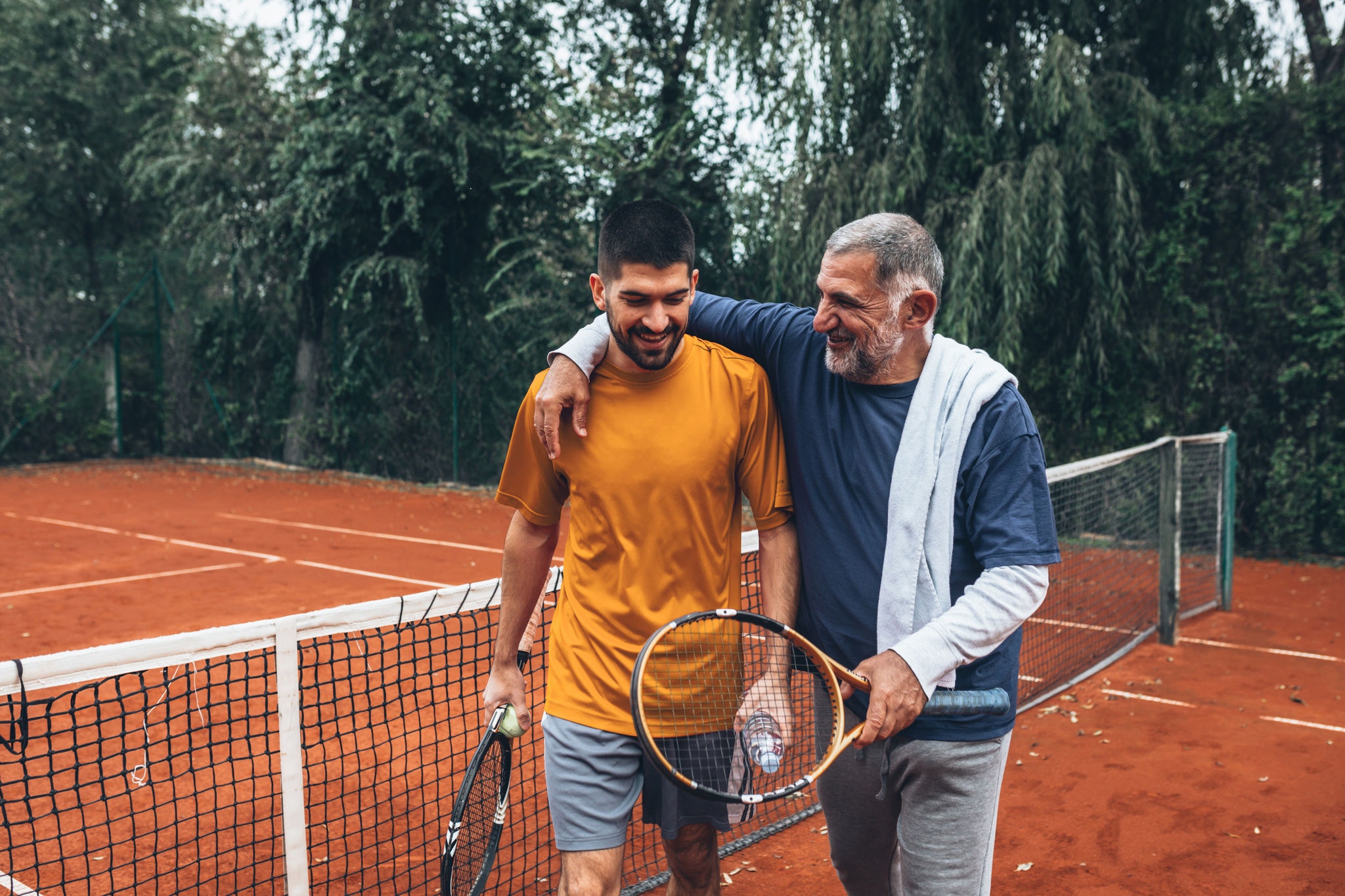 two friends after tennis game on court talking