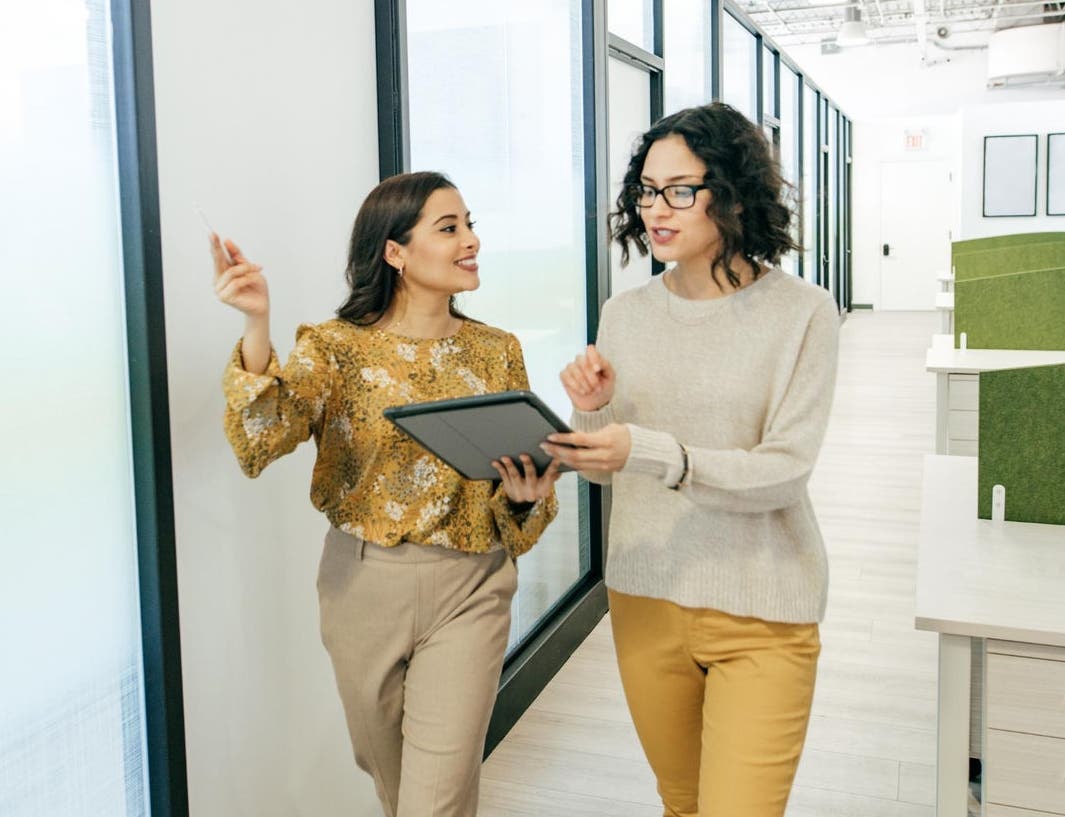 canva-colleagues-female-walking-discuss