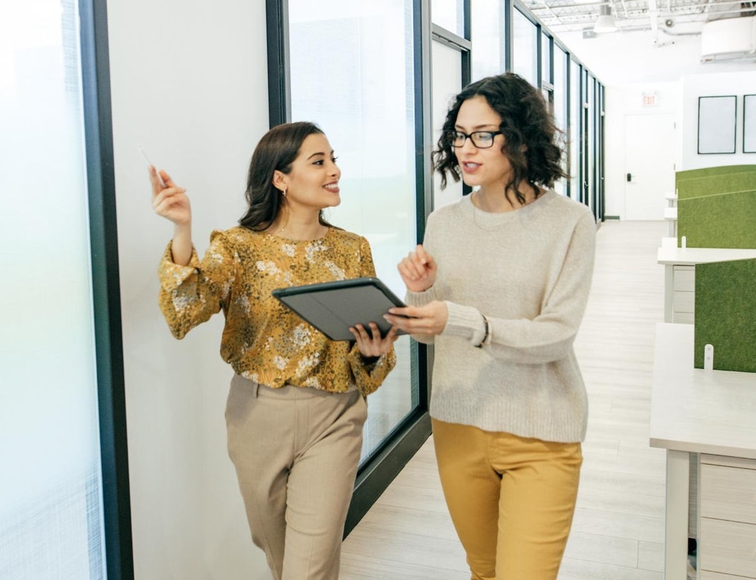 canva-colleagues-female-walking-discuss