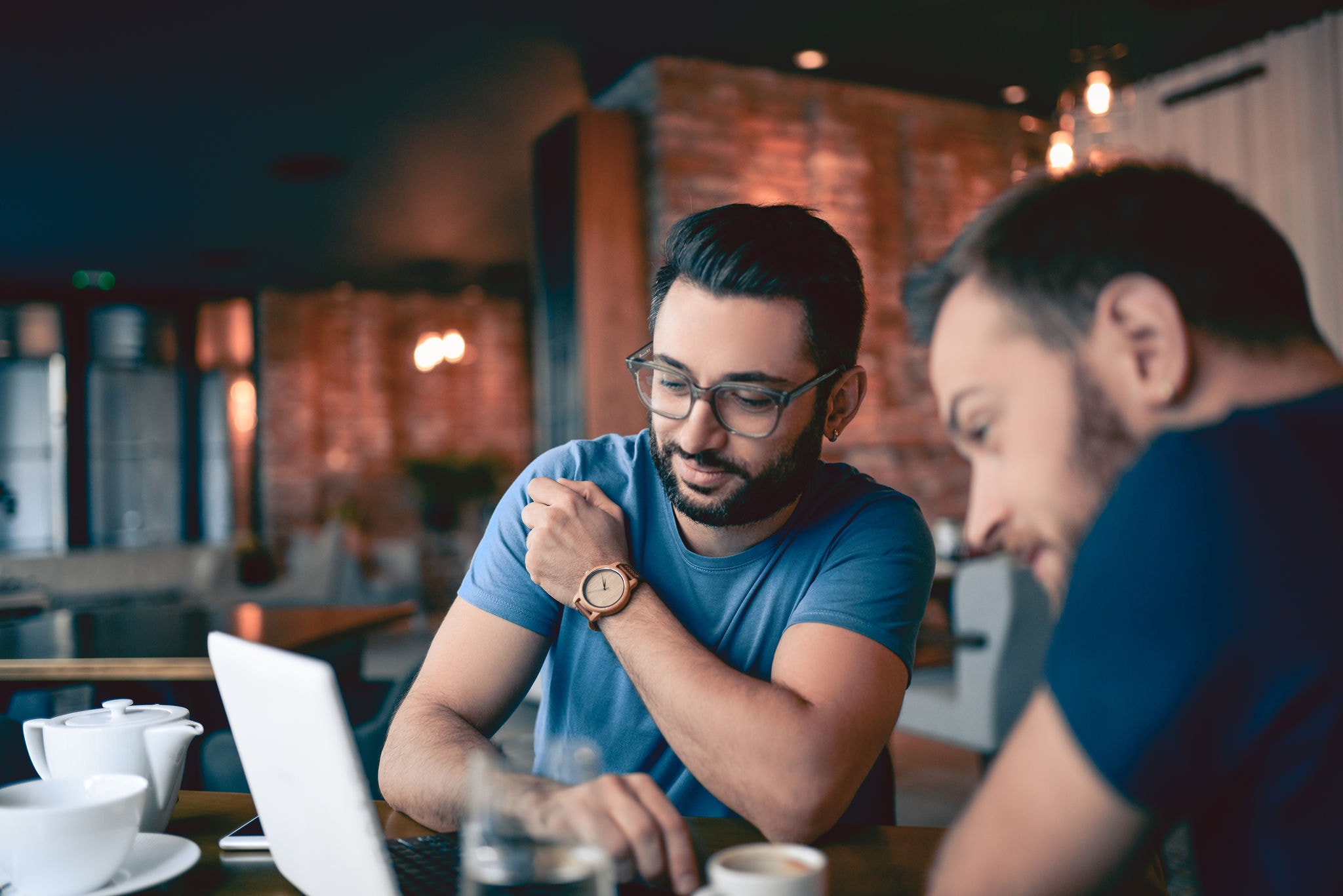 Two Handsome Friends Drinking Coffee and Surfing the Net In Cafe Restaurant