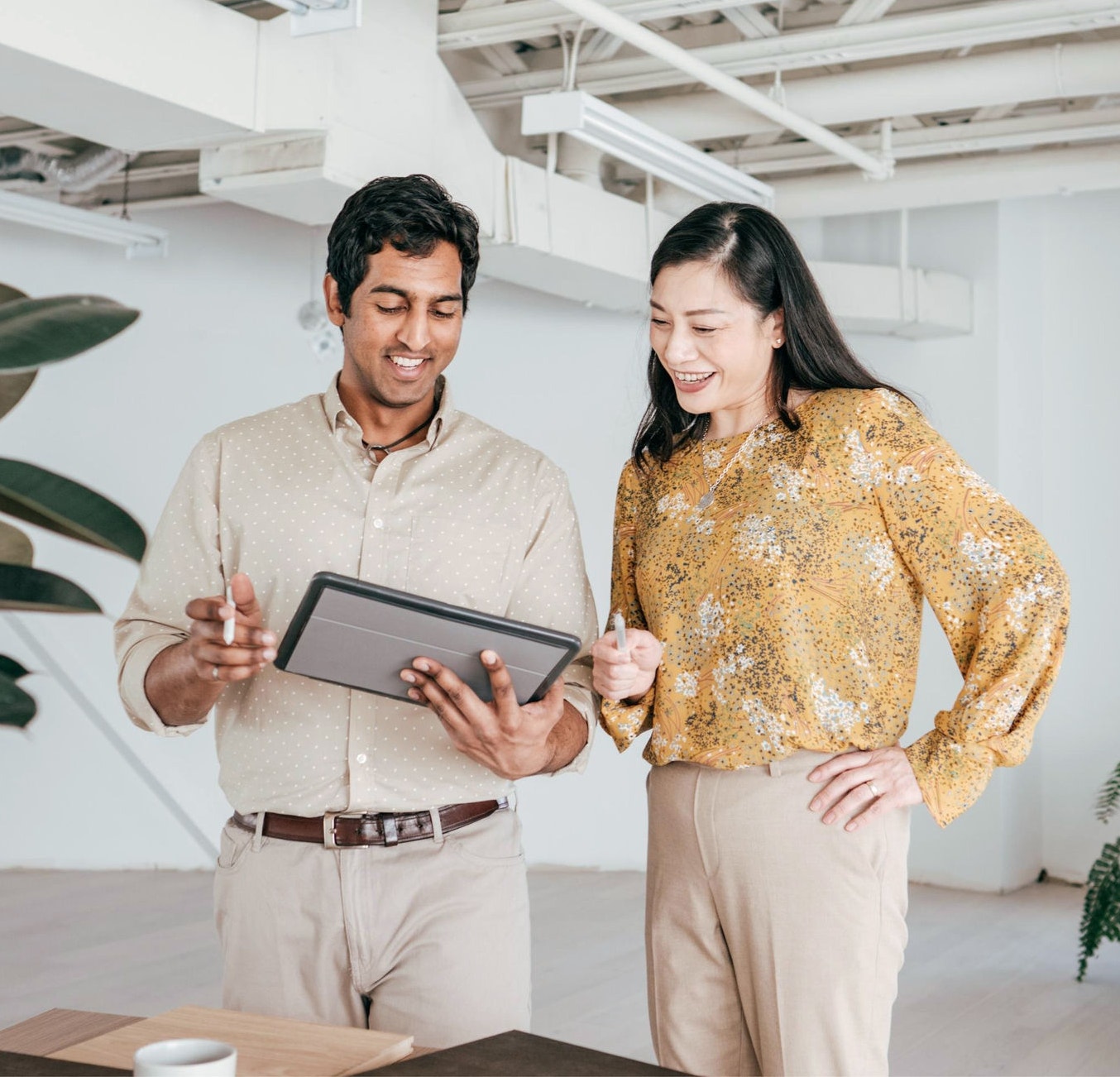 Colleagues standing in office looking at a tablet 