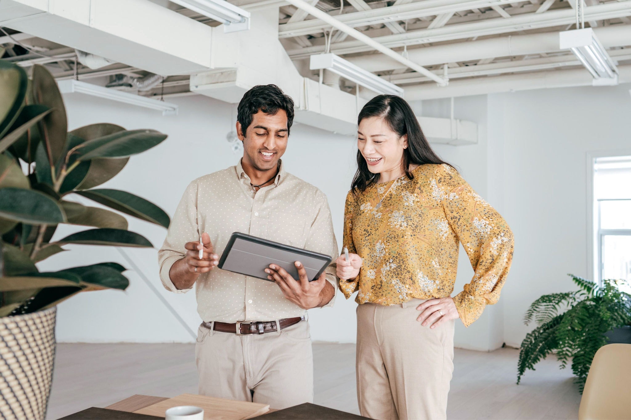 Colleagues standing in office looking at a tablet 