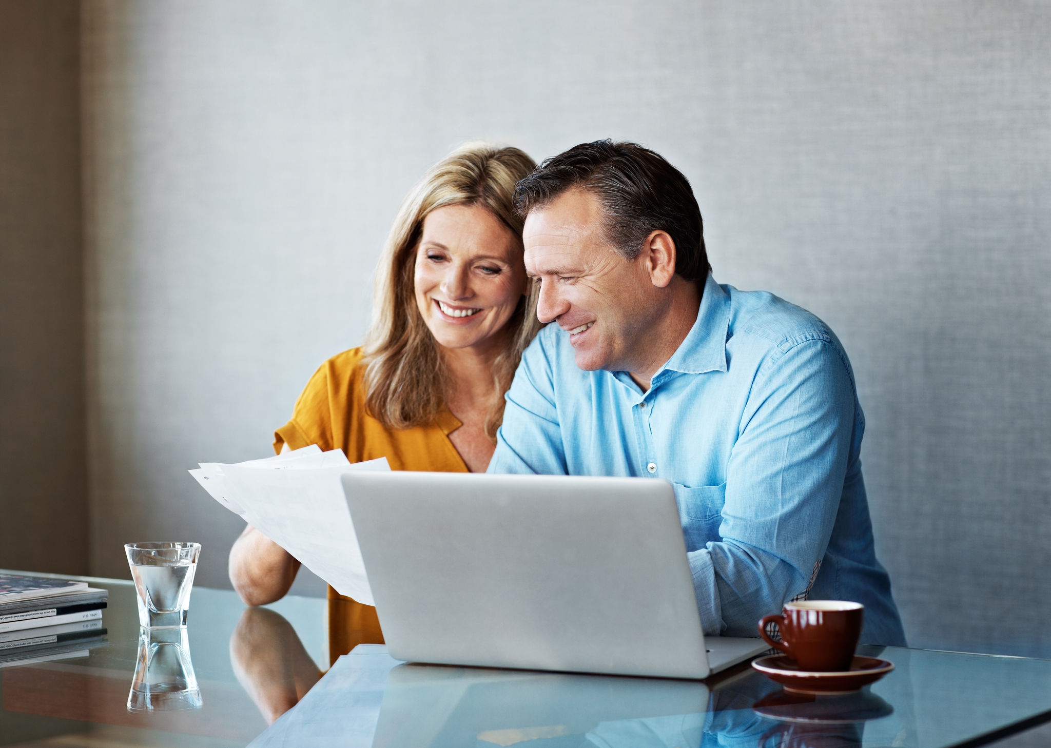 Shot of a mature couple paying their bills online from home