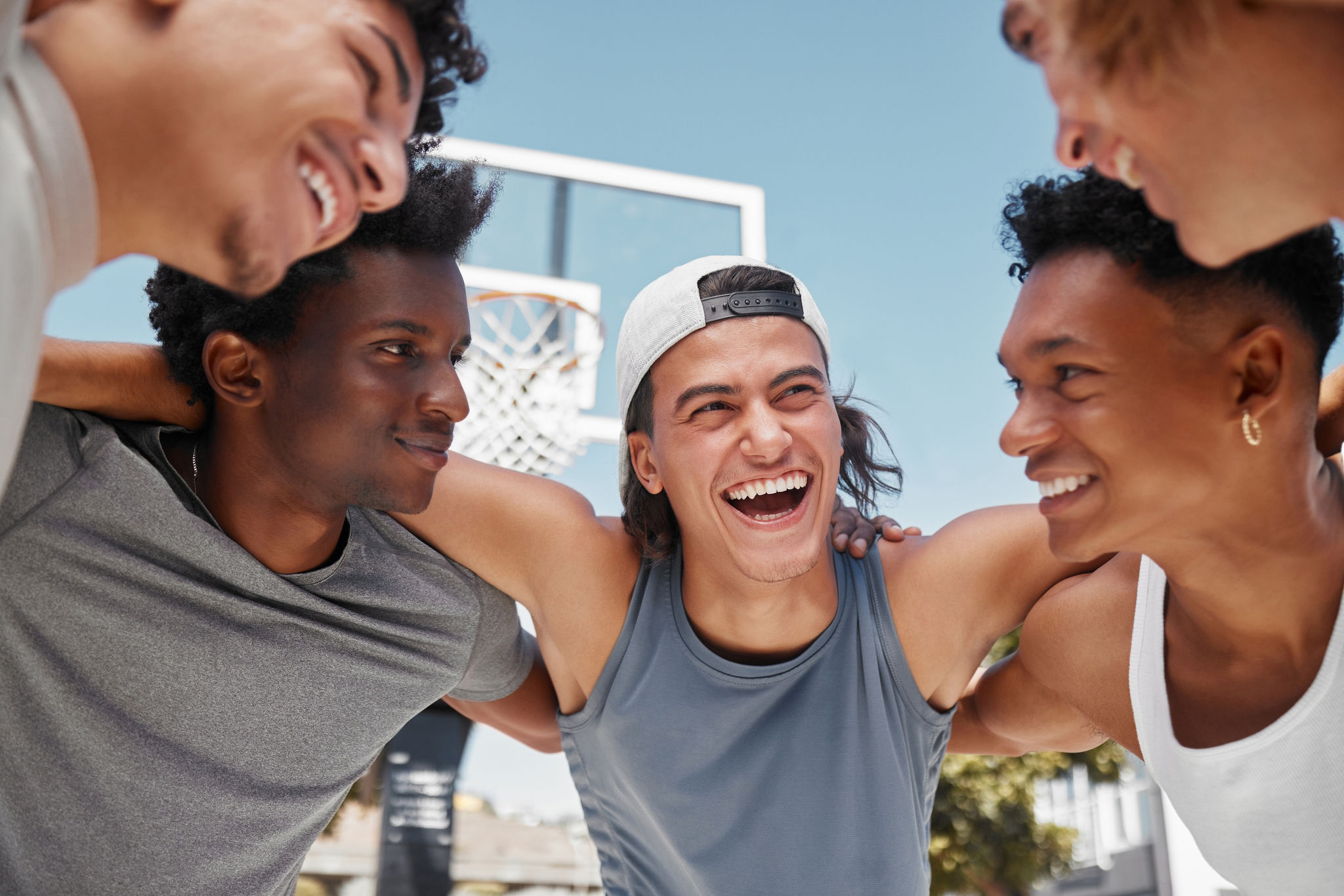 Happy, motivation and team building on a basketball court for a fitness mindset, teamwork and planning a strategy. Smile, support and funny sports men laughing, training or exercise with a mission.