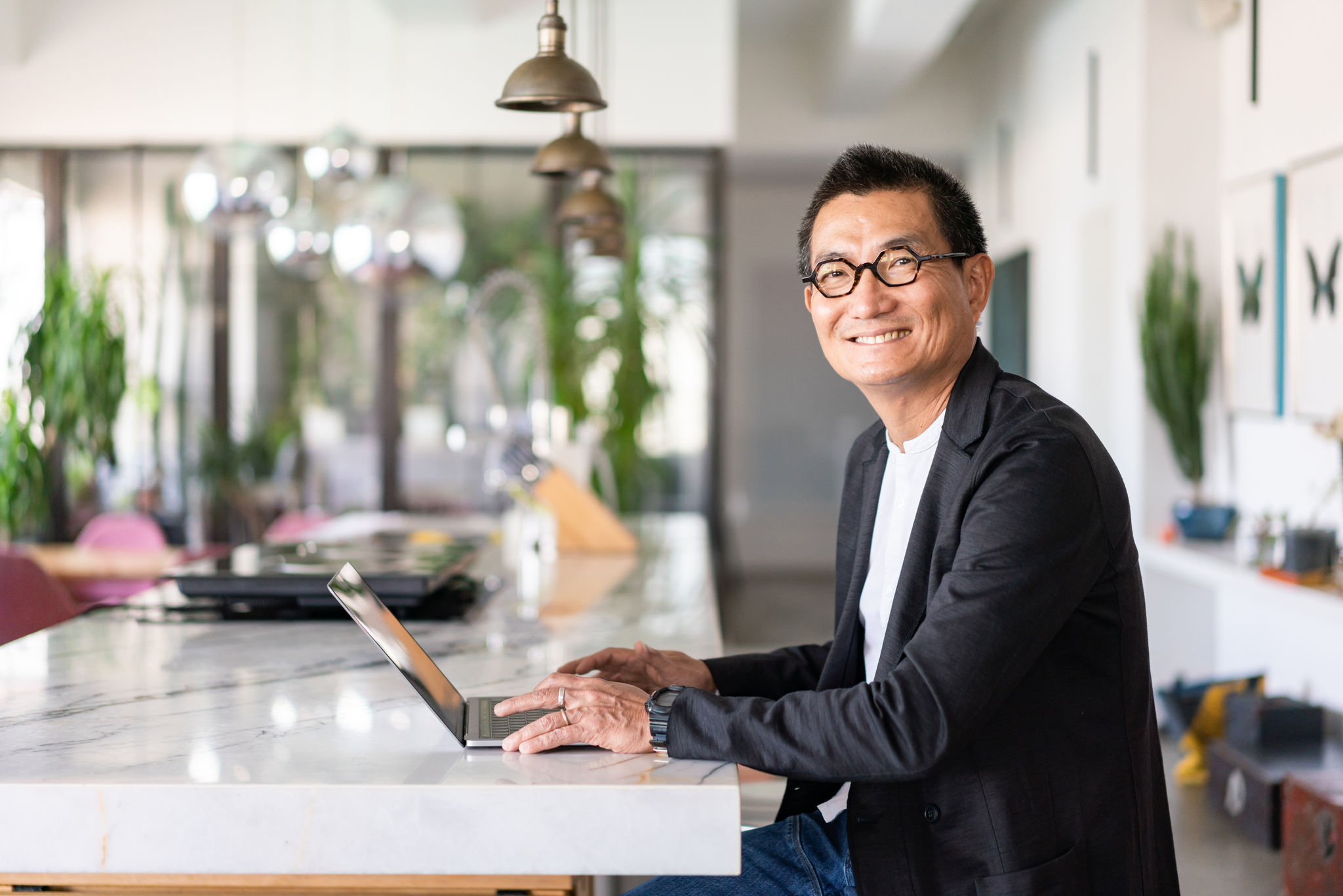 Man working on laptop at kitchen bench
