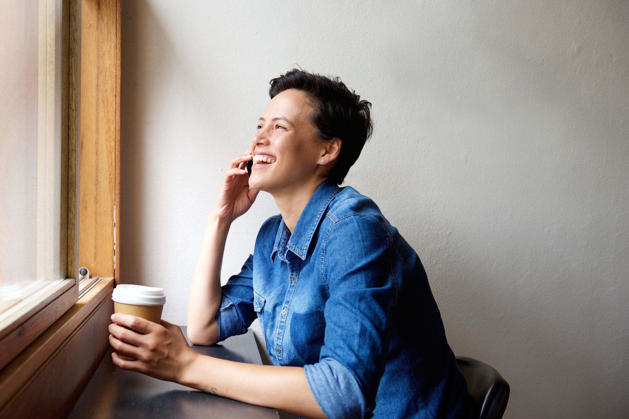 Side portrait of a young woman talking on mobile phone at cafe