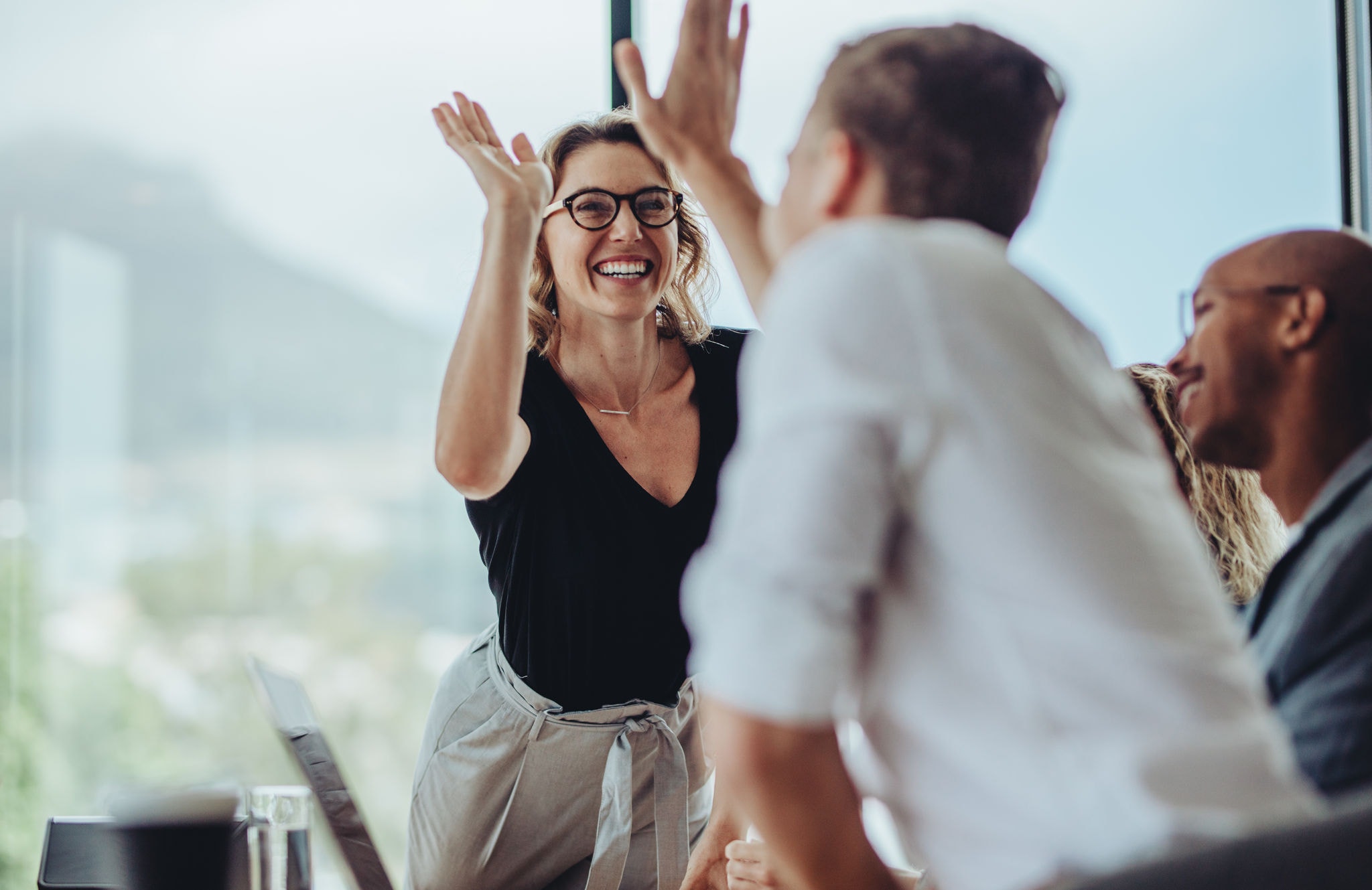 Businesswoman giving a high five to a colleague in a meeting