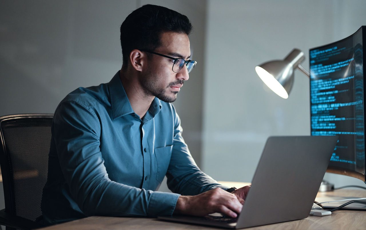 Laptop, screen and business man for coding, software development and programming script in cybersecurity. Night, computer research and programmer or IT person with html code, system or data analysis.