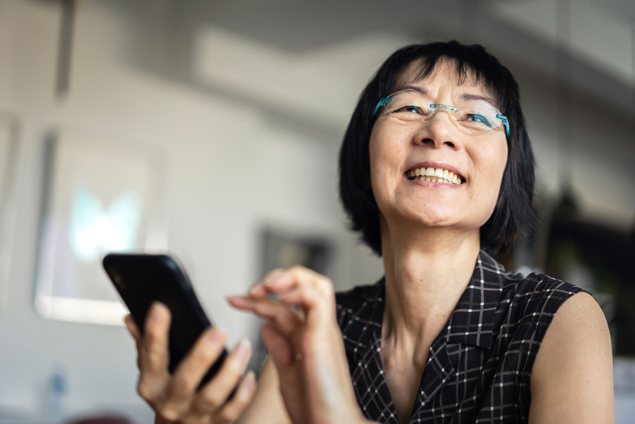 Woman laughing when using a smartphone