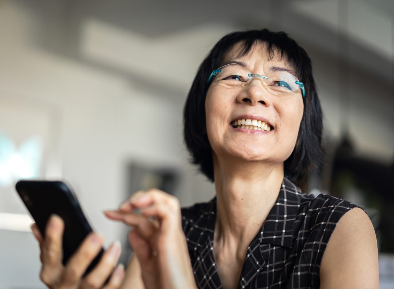 Woman laughing when using a smartphone